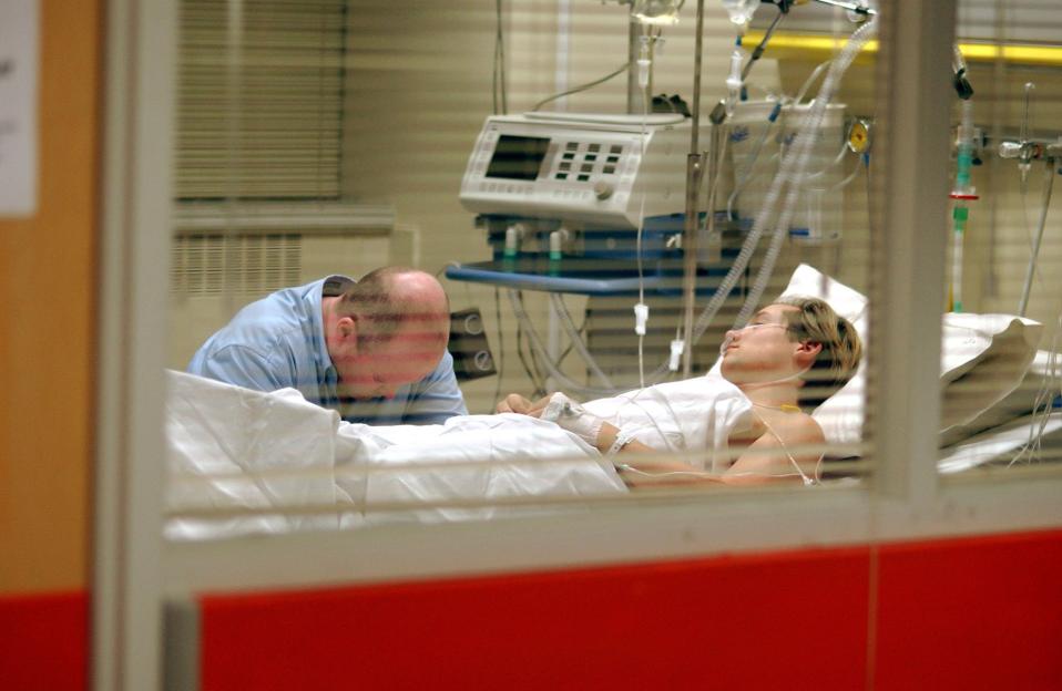 Phil (Steve McFadden) holding his head at Jamie's (Jack Ryder) bedside.