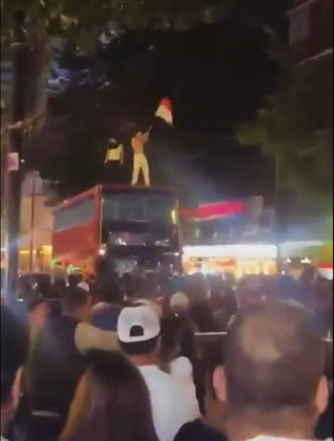Egyptian fans celebrate a win on Edgware Road by swarming the street and standing on a double-decker bus.