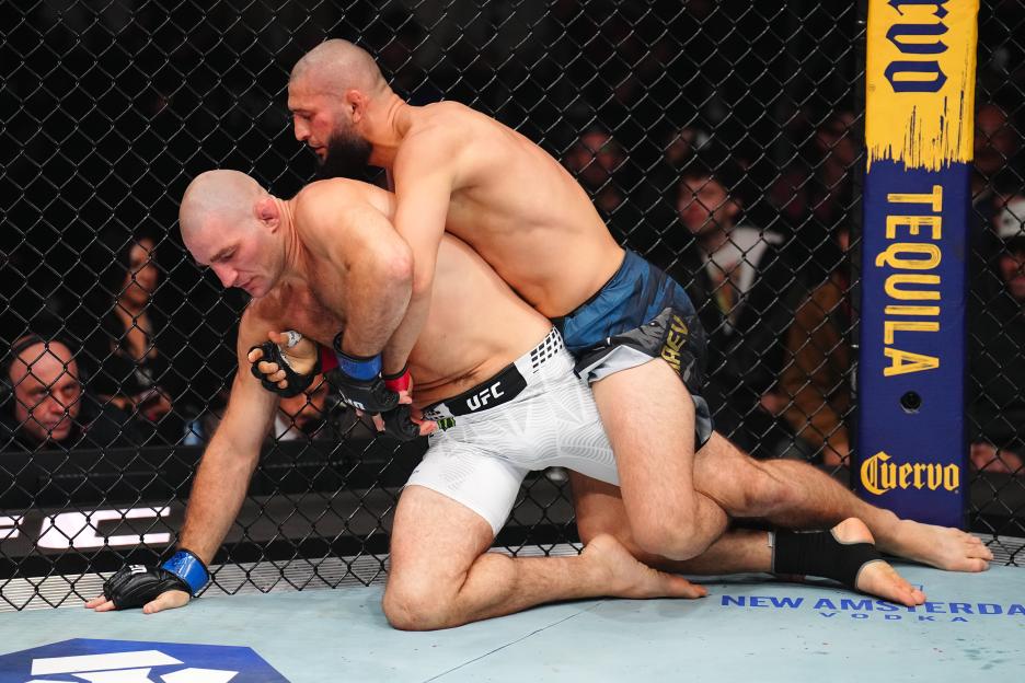 Khamzat Chimaev grappling with Sean Strickland in a UFC fight.