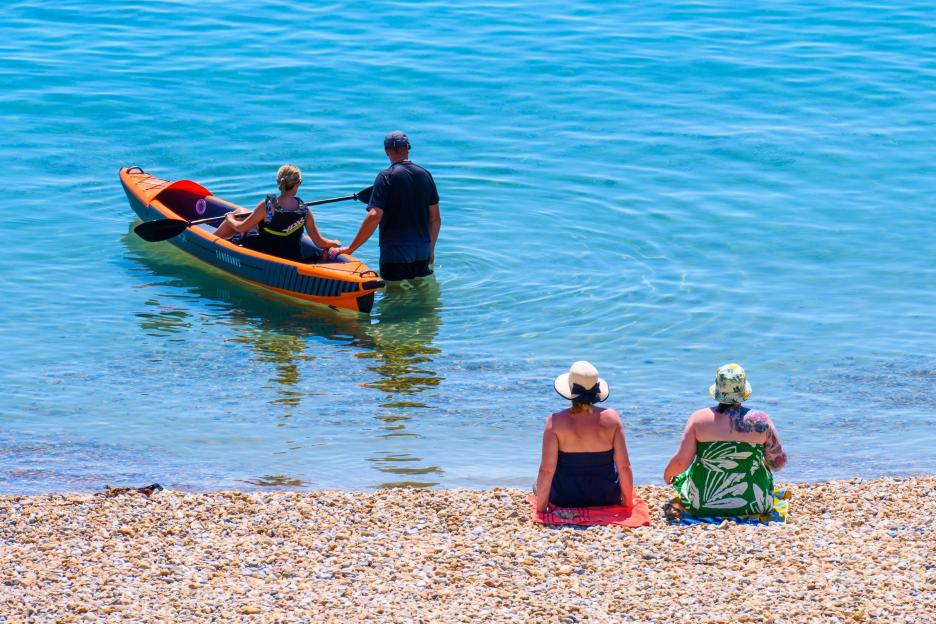Lyme Regis, Dorset, UK. 9th July, 2026. UK Weather: The beach at the seaside resort of Lyme Regis is busy with sunbathers soaking up scorching hot sunshine on Thursday afternoon. A July heatwave is predicted this week as temperatures continue to soar