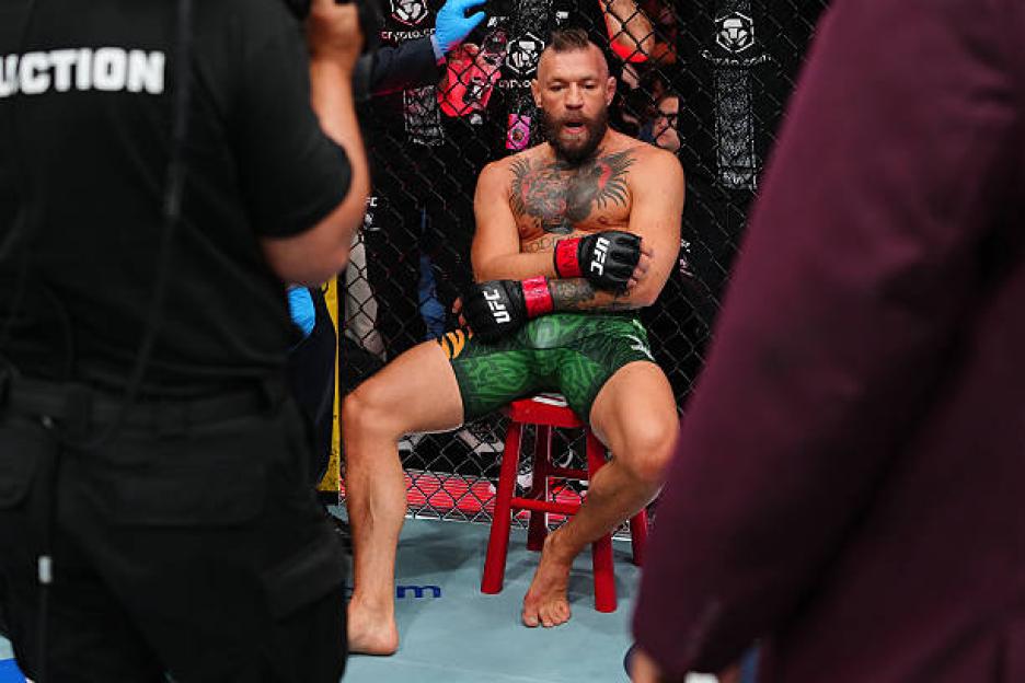 Conor McGregor sitting on a stool in a fighting ring.
