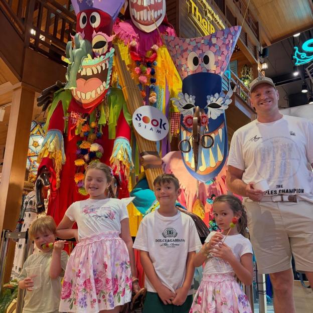 Tyson Fury and his four children pose in front of colorful Thai decorations.