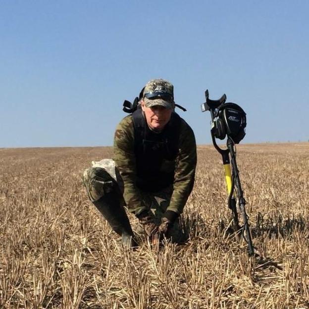 Man metal detecting in a river.