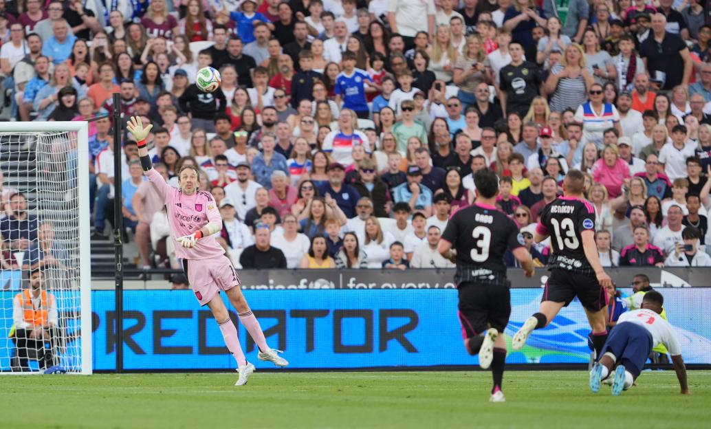 A Soccer Aid World XI FC goalkeeper blocks a shot during a match against England at London Stadium.