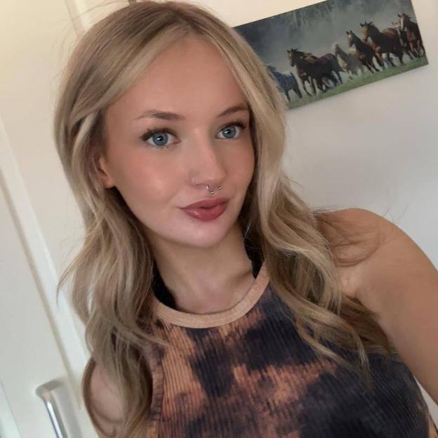 Woman with long blonde hair and a septum piercing.