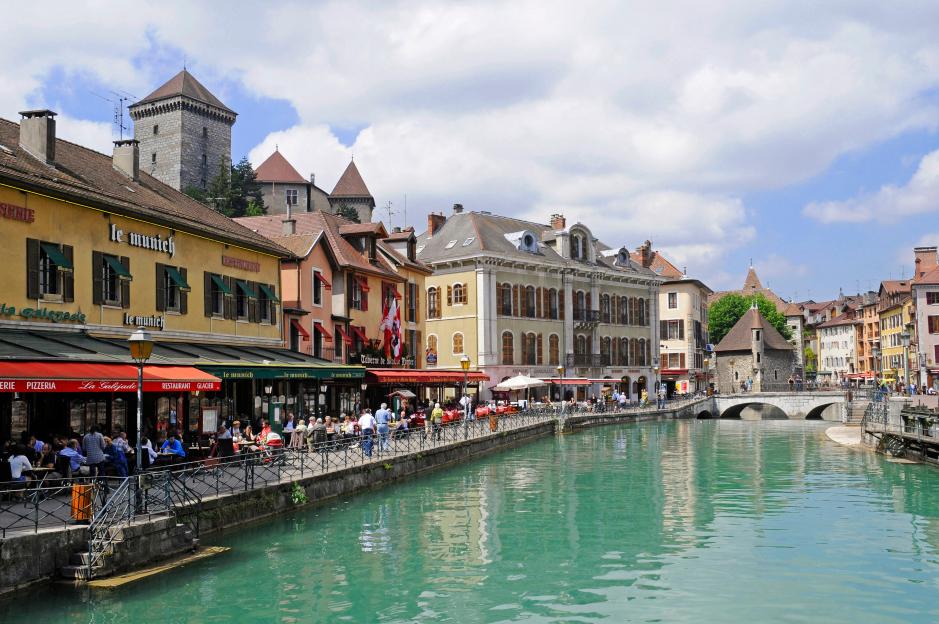The Thiou river in Annecy, France, with cafes and historic buildings lining its banks.