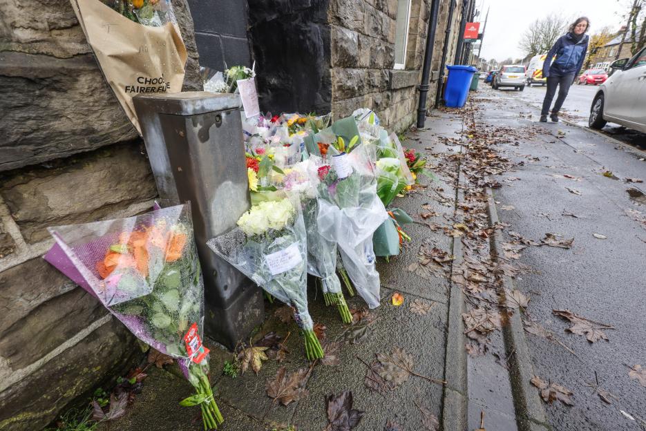 Floral tributes for Luke Harden on a sidewalk.