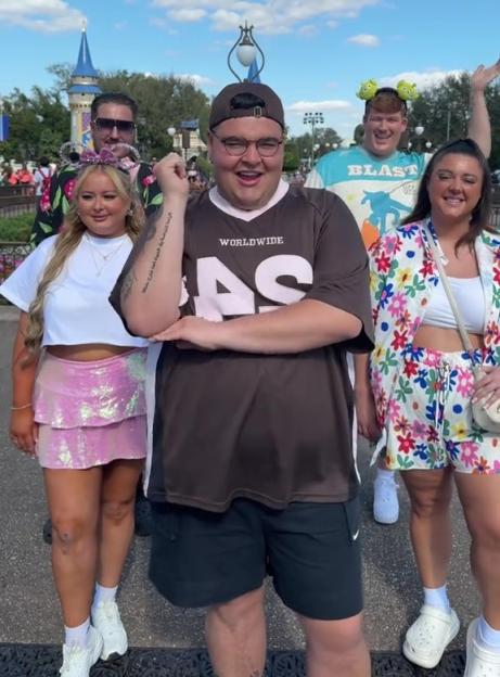 Five people posing in front of Cinderella's Castle at Disney World.