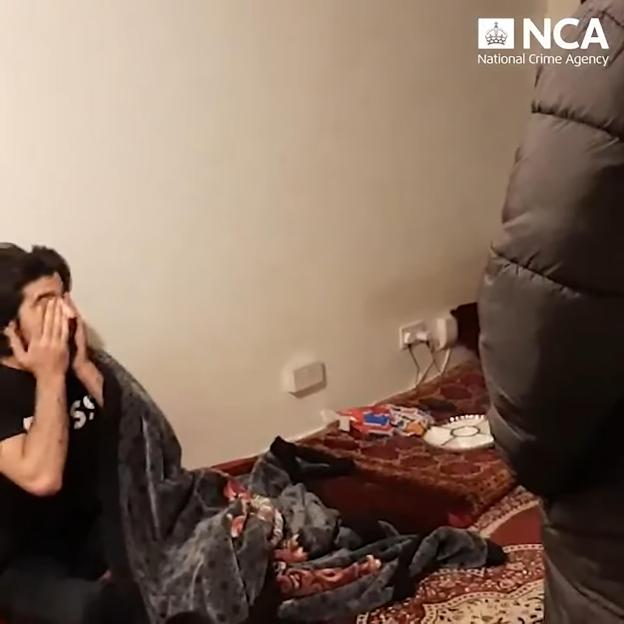 Saifur Ahmedzai covering his face during his arrest by the National Crime Agency (NCA).