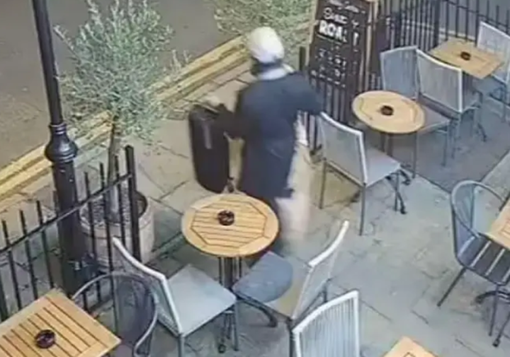 CCTV footage showing Ahmed Sami Madour allegedly stealing a violin from a pub's outdoor seating area.