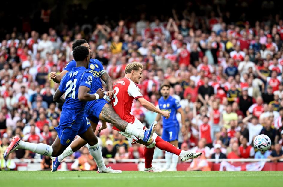 Arsenal FC player Martin Ødegaard shoots the ball during a match against Chelsea FC.