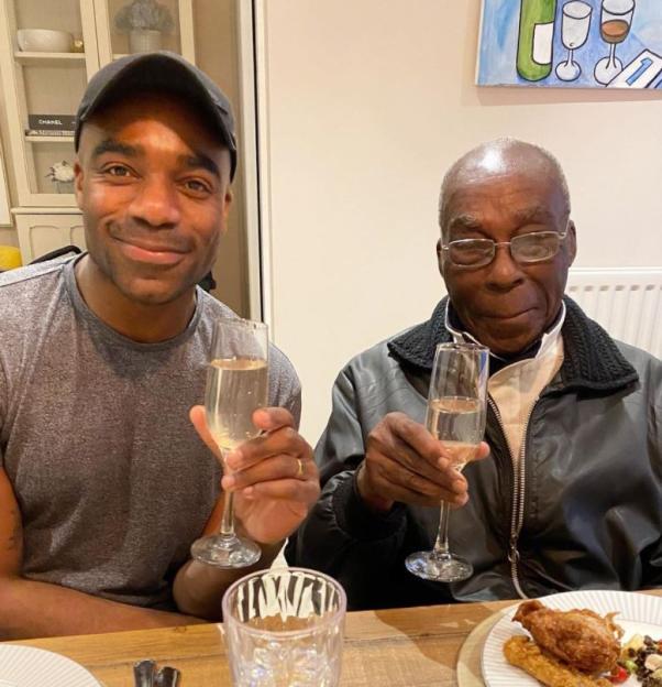 Ore Oduba and his father raising champagne glasses.