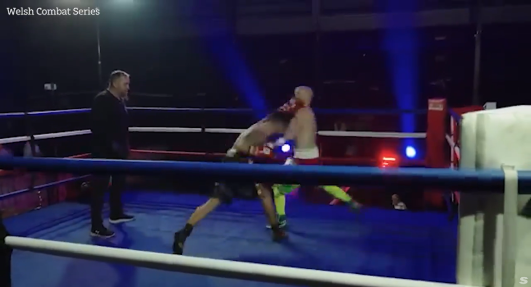 Two boxers fighting in a ring with a referee observing.