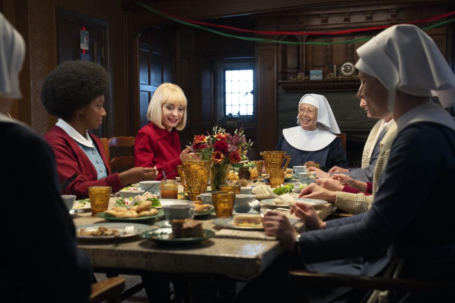Sisters and friends gather around a table for a meal.
