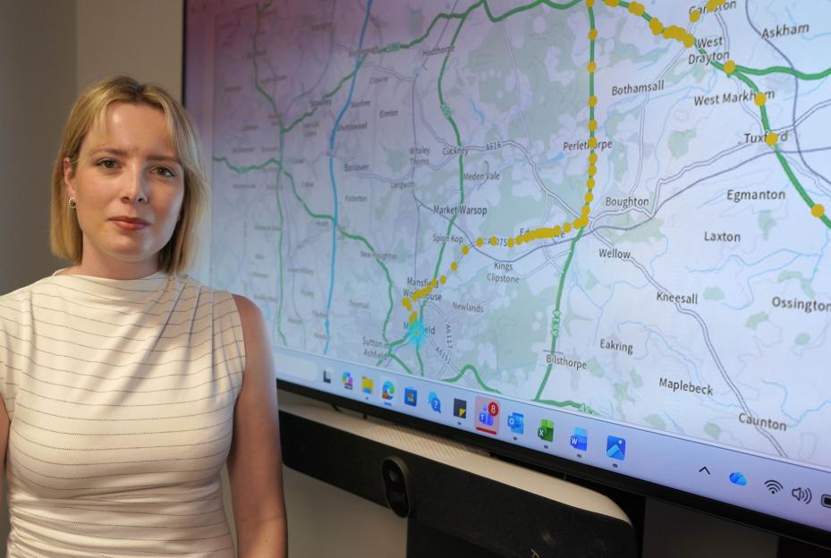 A woman stands in front of a screen displaying a map with a yellow dotted line showing Julia Atherley's GPS-tagged route from HMP Ranby prison.