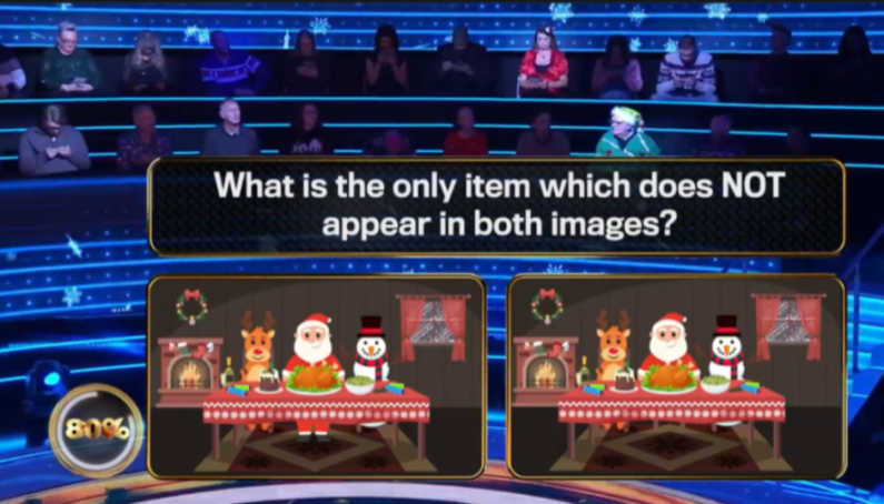 A quiz show screen displays a question: "What is the only item which does NOT appear in both images?" Below are two side-by-side illustrations of a Christmas dinner scene with Santa, a snowman, and a reindeer.