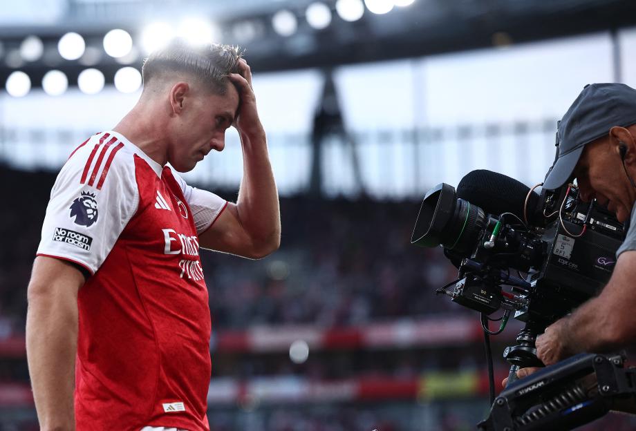 Viktor Gyökeres of Arsenal with a hand on his head, next to a camera operator at the Emirates Stadium.