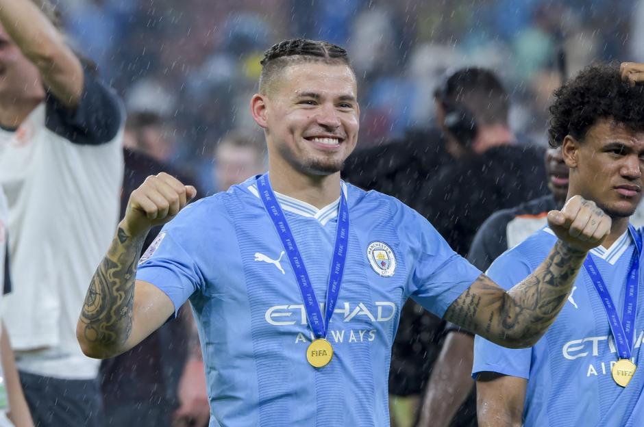 Kalvin Phillips of Manchester City celebrating with a gold FIFA medal around his neck.