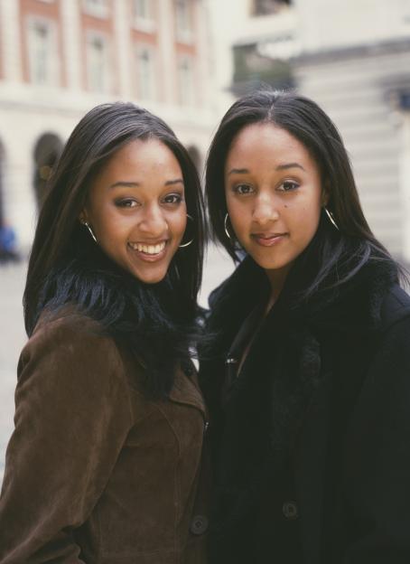 Tia and Tamera Mowry of "Sister, Sister" smiling outdoors.