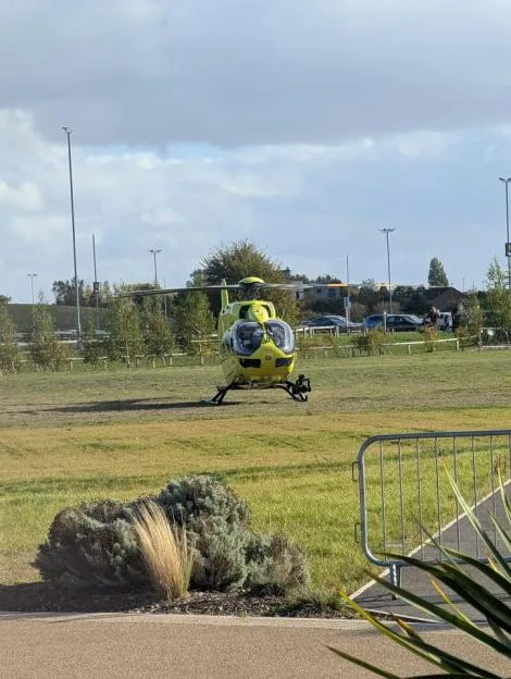 A yellow air ambulance helicopter landed in a grassy area at Yorkshire Wildlife Park.