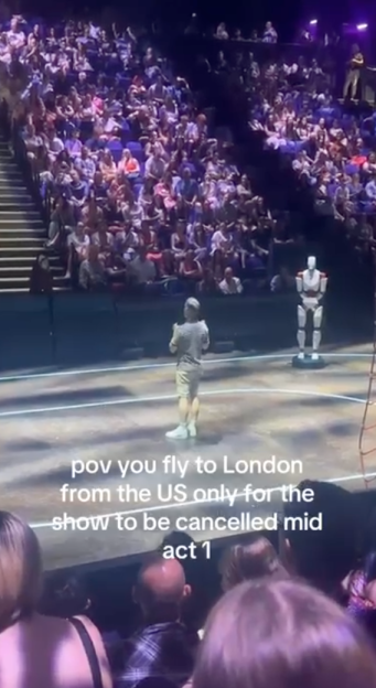 A live show audience watching a man and a robot on stage, with text overlaid expressing frustration about the show's cancellation.