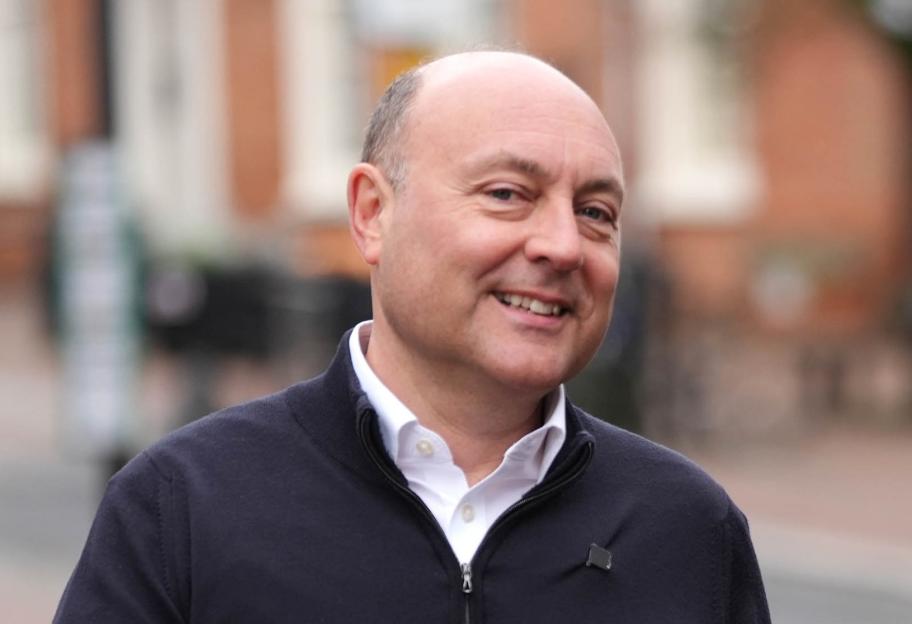 Kemi Badenoch and Andrew Griffith walking and smiling.