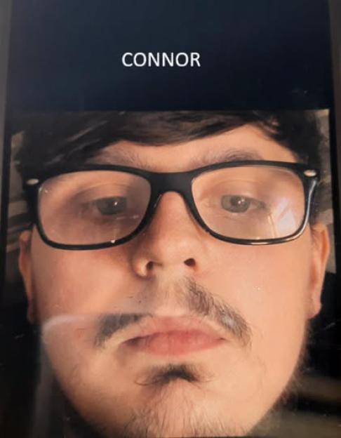 A man with dark hair, glasses, and a mustache.