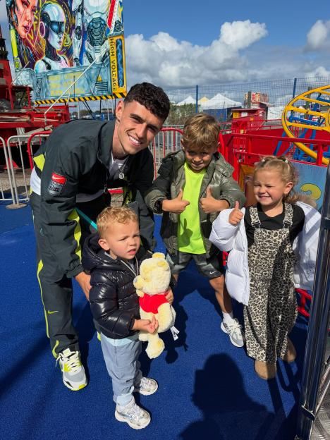 Phil Foden with his children Ronnie, True, and a younger boy at an amusement park.