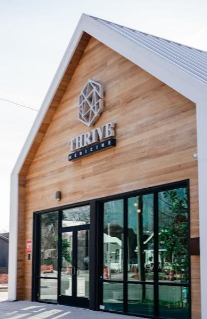 Exterior of the Thrive Medicine Clinic, a modern building with a wood facade and a white gable roof.