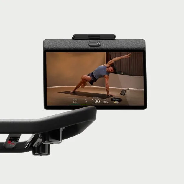 A treadmill screen displaying a man in a yoga pose with workout metrics.