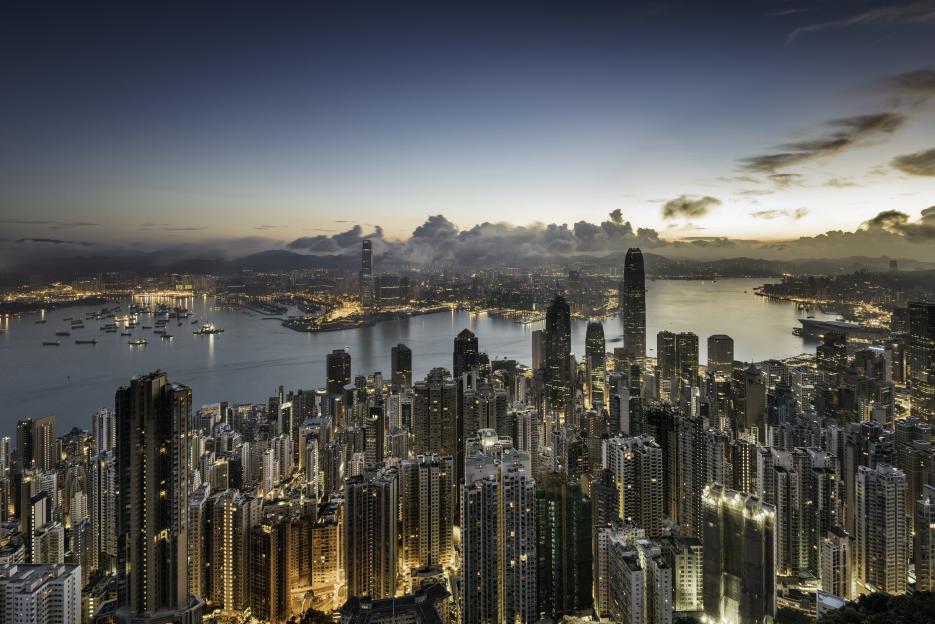 Elevated view of the Hong Kong skyline and Victoria Bay at dawn, showing the financial district.