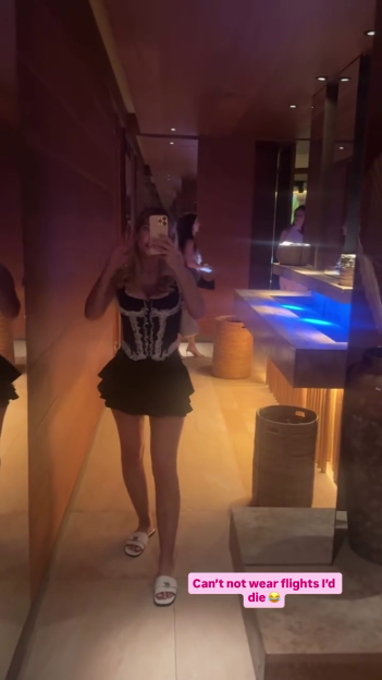 Helen Flanagan takes a mirror selfie wearing a black and white corset top and a black mini skirt.