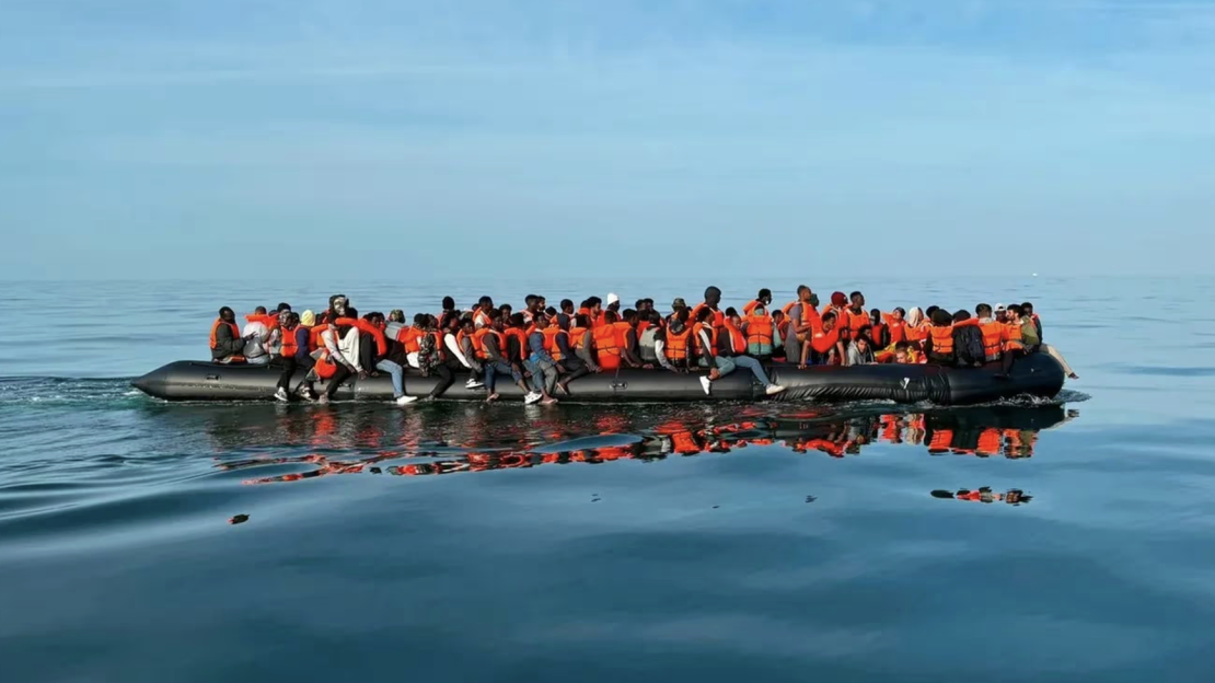 Overloaded inflatable boat carrying approximately 150 migrants.