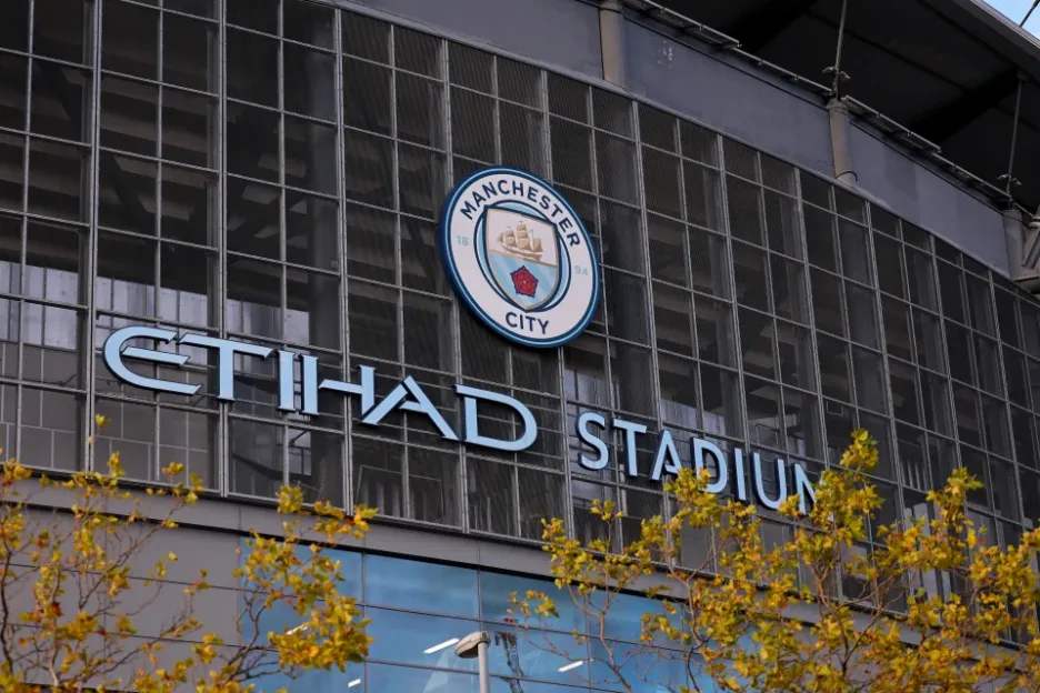 Exterior view of Etihad Stadium with the Manchester City logo.