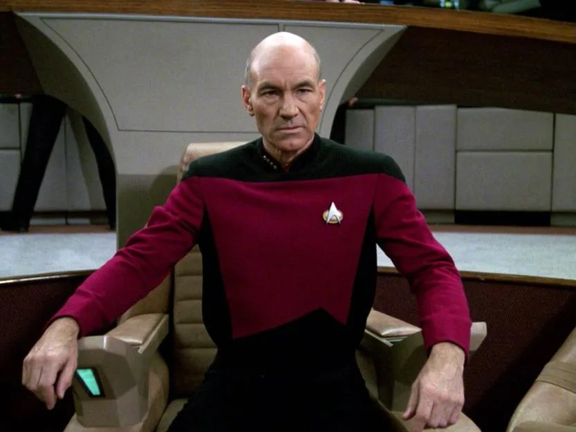 Patrick Stewart as Captain Jean-Luc Picard seated on the bridge of the USS Enterprise in Star Trek: The Next Generation.