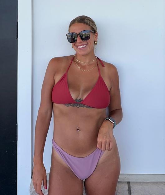 Lex Banach, smiling in a red bikini top and lavender bikini bottom after her 60-pound weight loss.