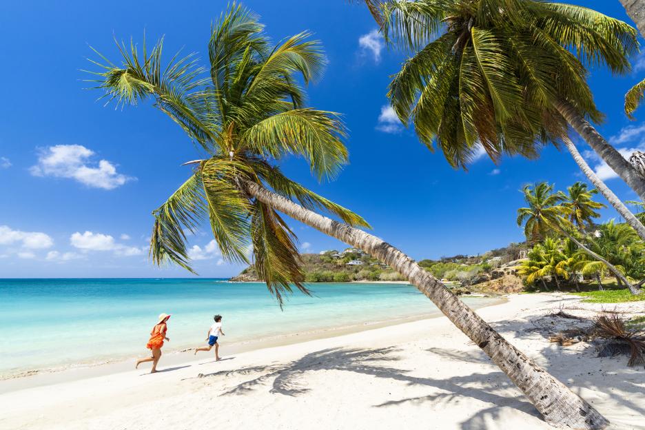 Mother and son running on a tropical beach.