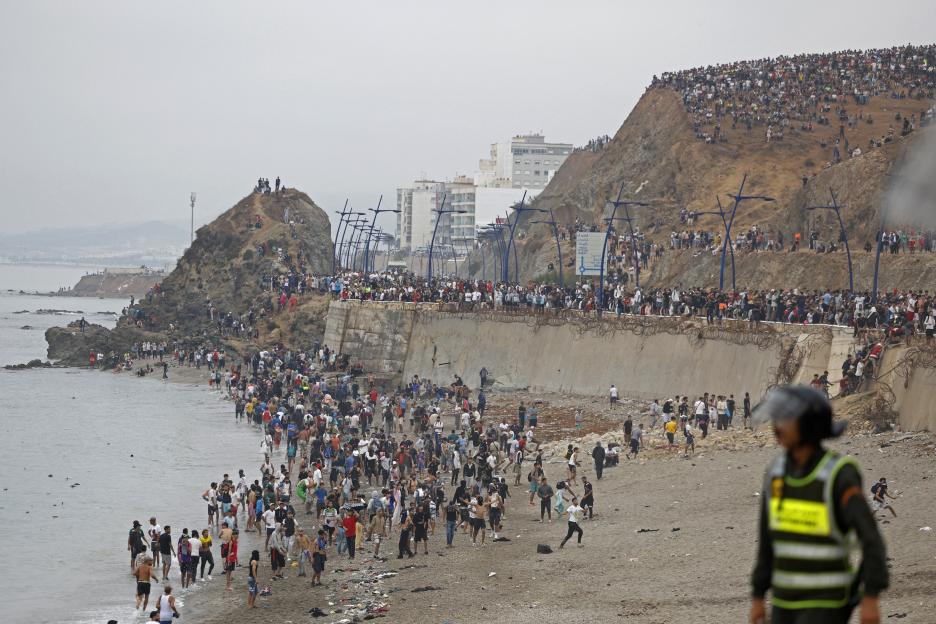People gather along the fence at the site of clashes near Fnideq, on the Morocco-Spain border.