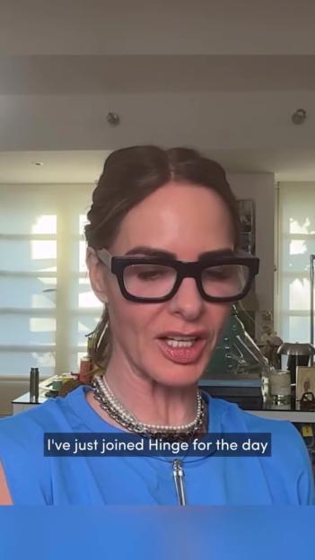 Trinny Woodall in black-framed glasses and a blue top speaking.
