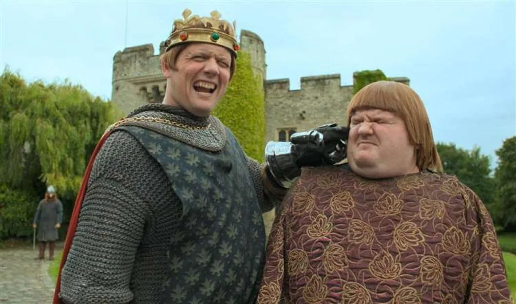 David Mitchell and Robert Webb in medieval costumes outdoors with a castle in the background.