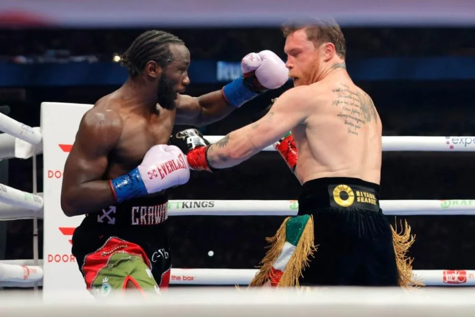 Terence Crawford and Canelo Alvarez trading punches in the boxing ring.