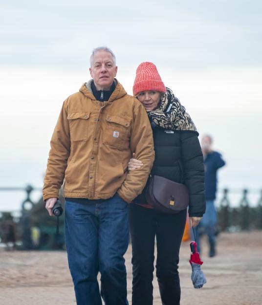 Zoe Ball and Mat Weekes walk arm-in-arm along the Brighton seafront.