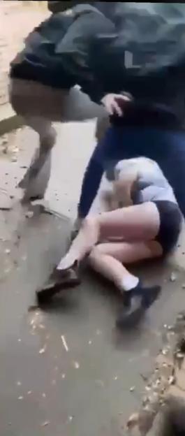 A person kicking Jade Chantrell's daughter while she is on the ground.