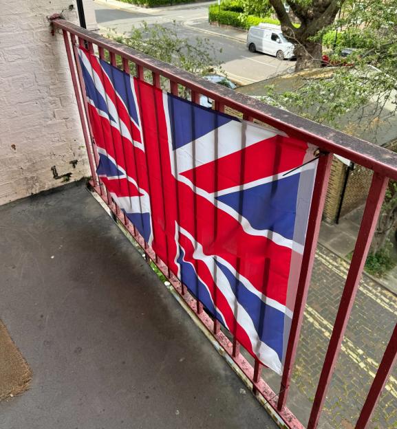A Union Flag displayed on a balcony railing.