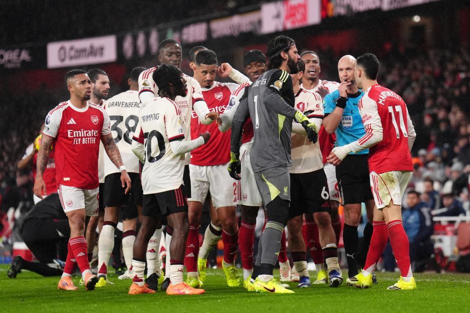 Players from Arsenal and Liverpool, and a referee, react on the pitch at Emirates Stadium.