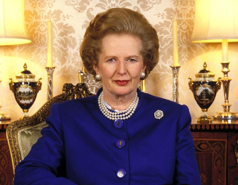 British Prime Minister Margaret Thatcher, wearing a blue suit and pearl necklace, sits for an interview.