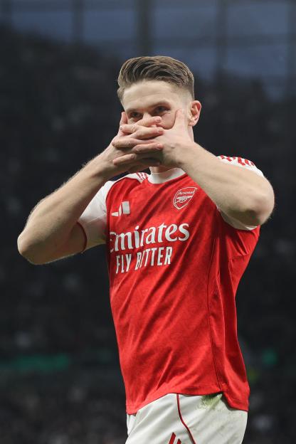 Arsenal player Emile Smith Rowe celebrates a goal with his hands covering his face during a match against Tottenham Hotspur.