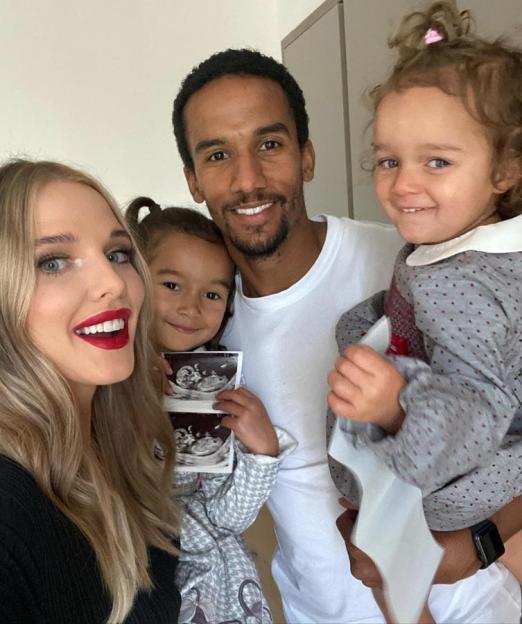 Helen Flanagan, Scott Sinclair, and their two daughters pose, with one daughter holding ultrasound photos.