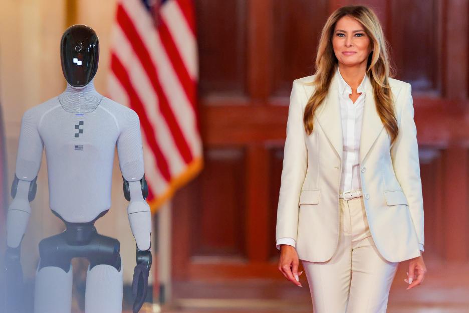 Melania Trump walks beside a humanoid robot in the East Room of the White House.
