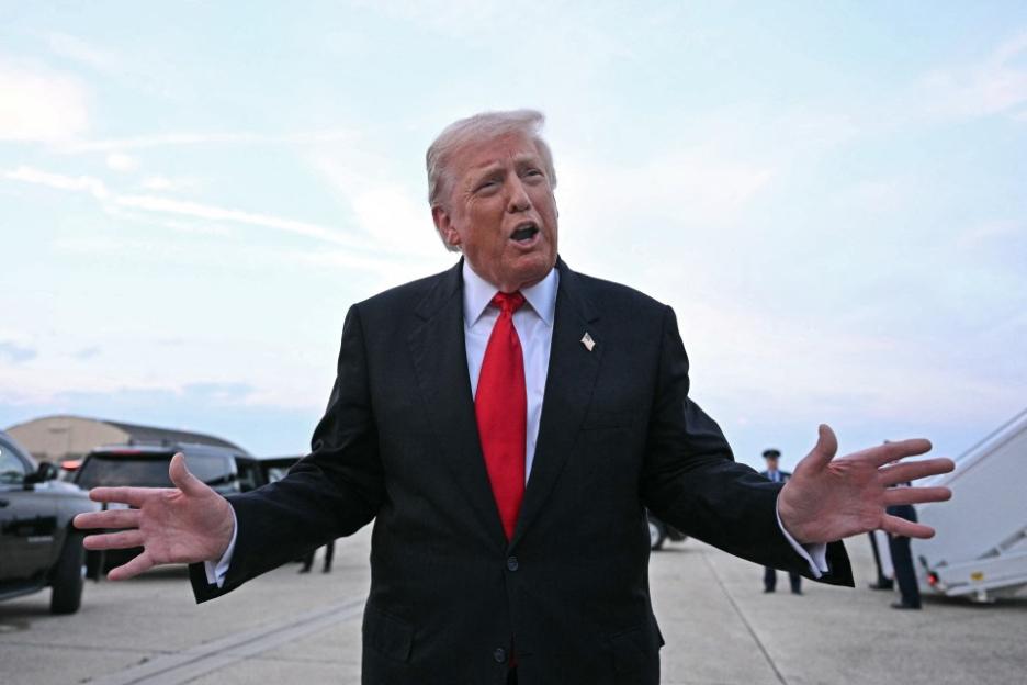 Donald Trump speaking with his arms outstretched.